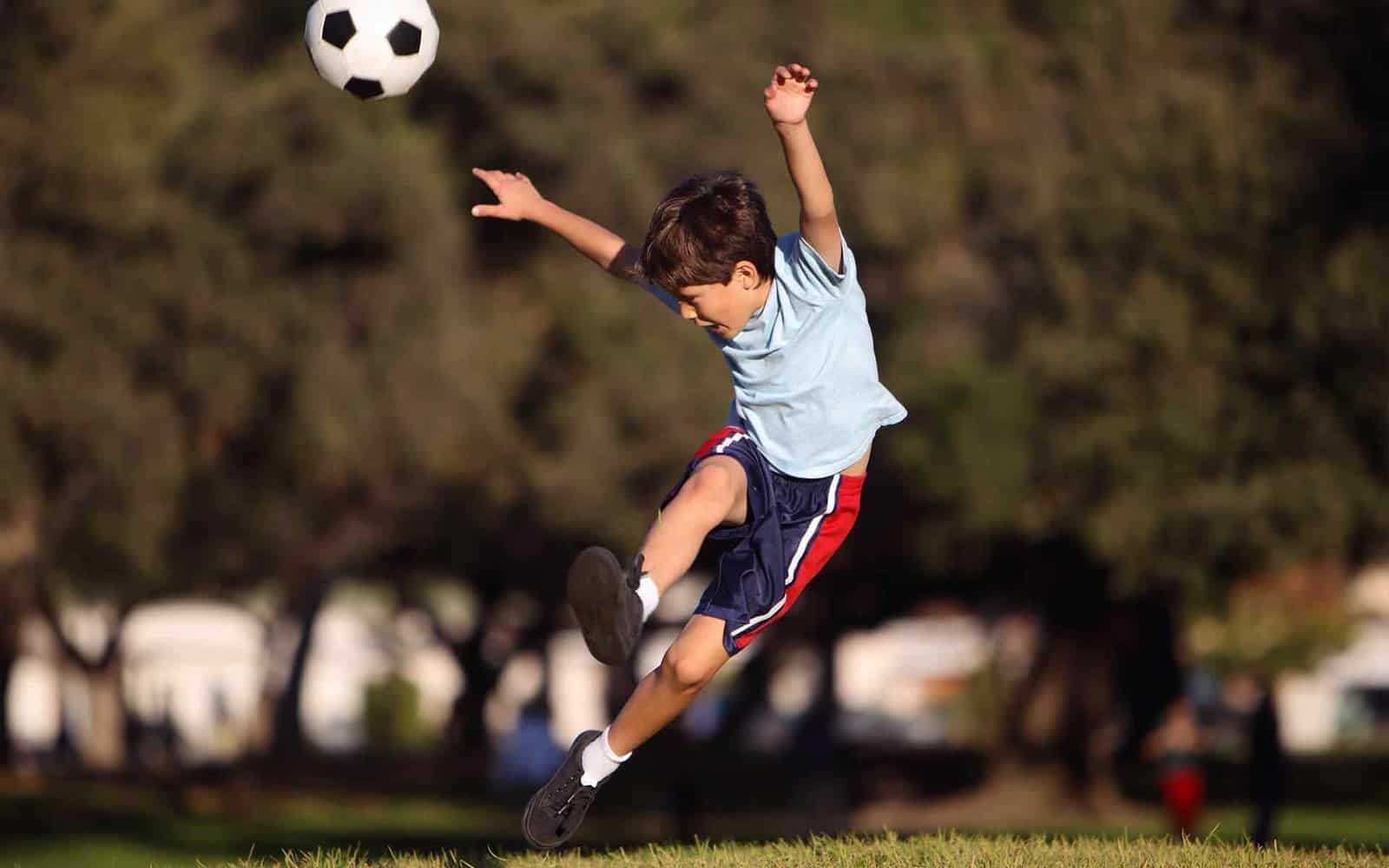 Youth soccer player performing aerial kick during practice at Osaro International Sports Academy.
