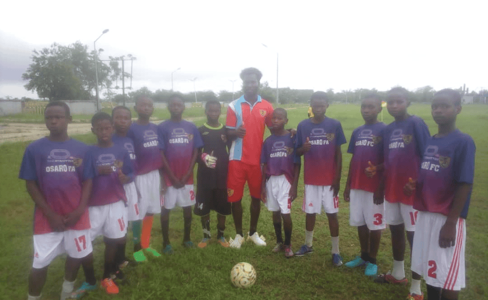 Osaro International Sports Academy youth soccer team pose on field in team jerseys.