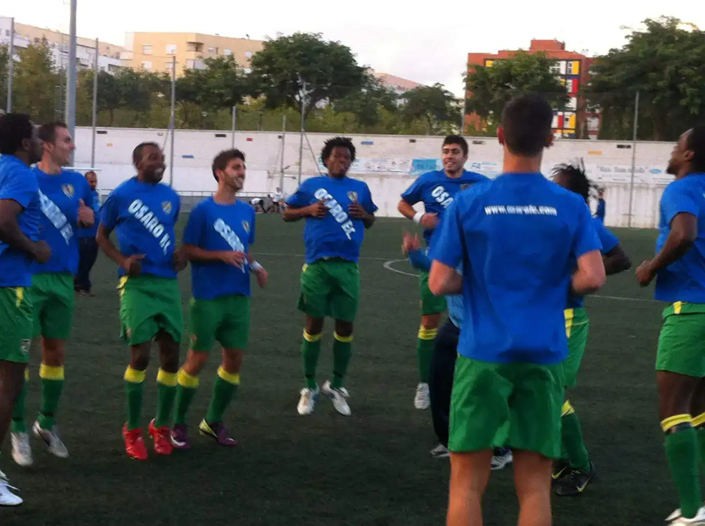 Youth soccer team celebrating on the field at Osaro Intl Sports Academy.