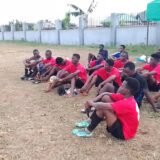Young athletes listening to coach during training at Osaro Intl Sports Academy.